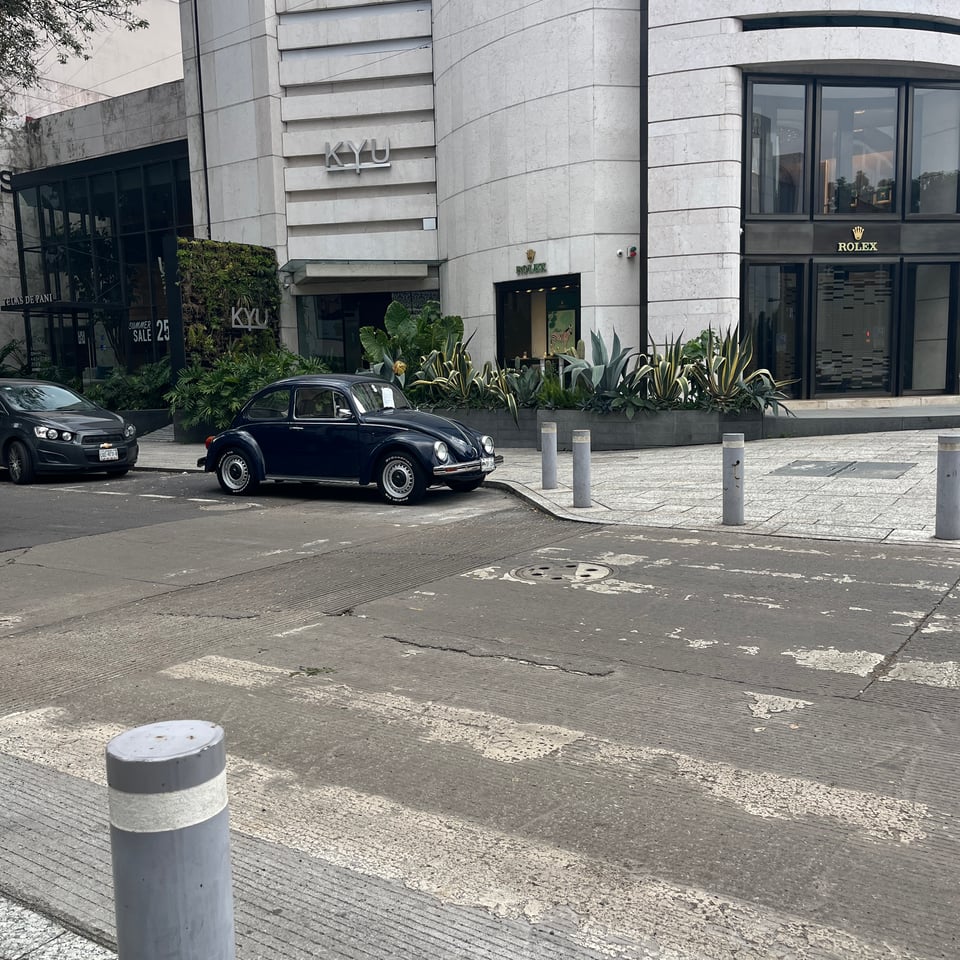 A photo of the car parked in front of a Rolex store.