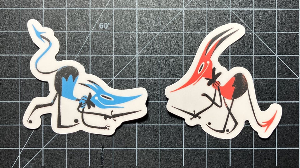Two stickers, each of a goblin holding a knife. The blue one on the left crouches to attack, and the red one on the right prepares to defend.