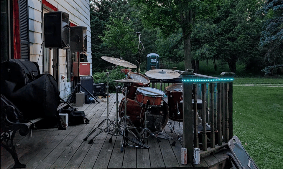 a deck with PR speakers, guitar amps and a drum kit