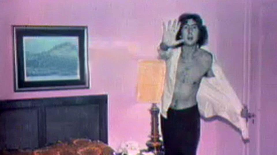 a man standing in front of a pink wall