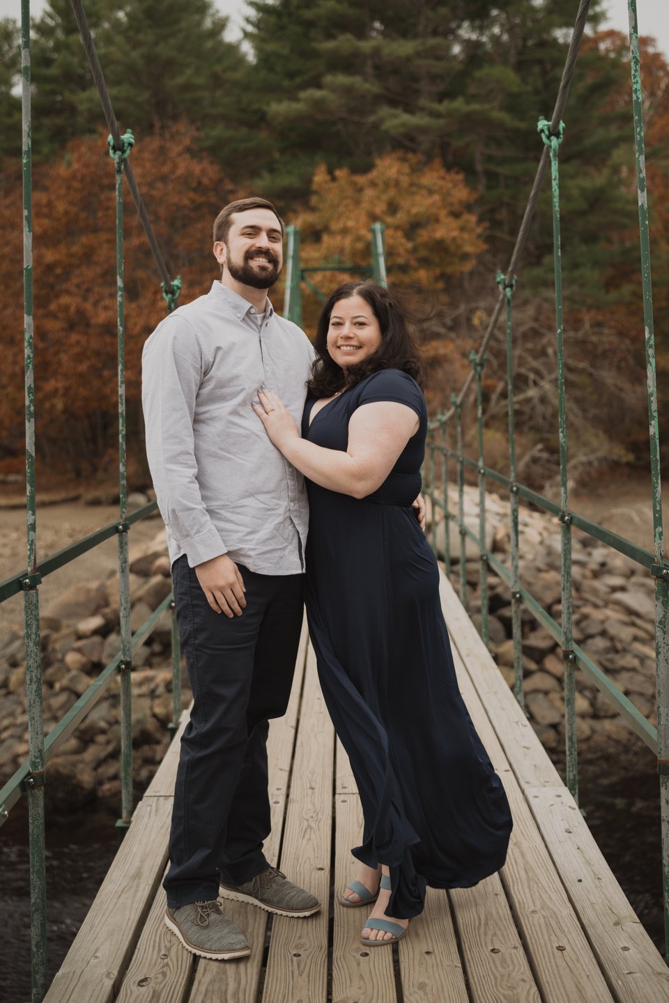 an engaged couple on a bridge