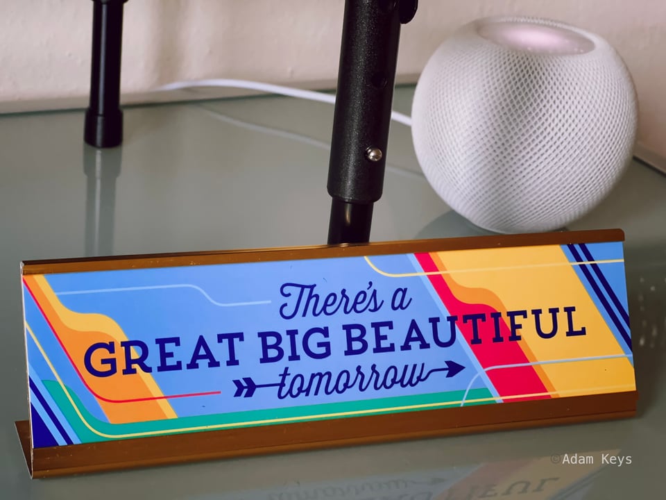 Desk sign reading "There's a Great Big Beautiful Tomorrow"