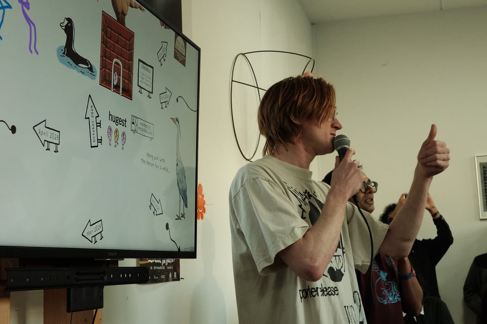 Host in front of a crowd shows a thumbs up