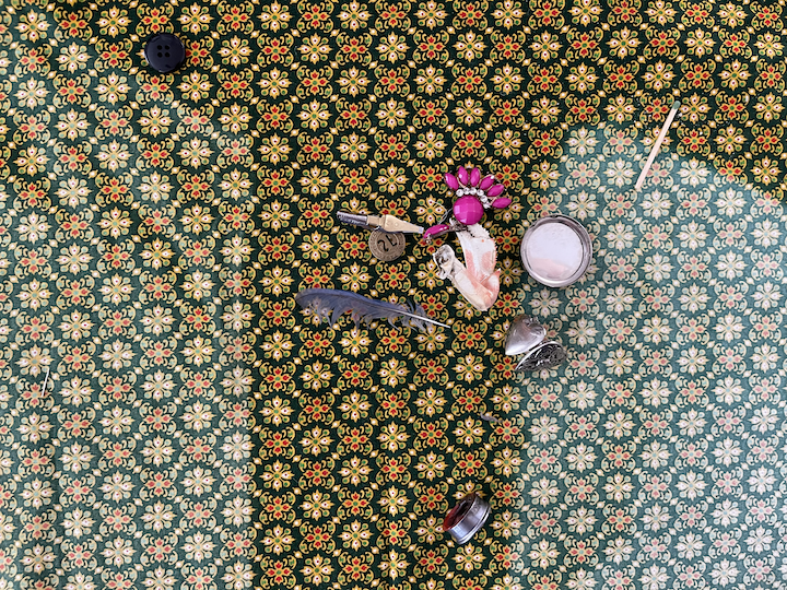 A collection of trinkets arranged on a mat randomly.