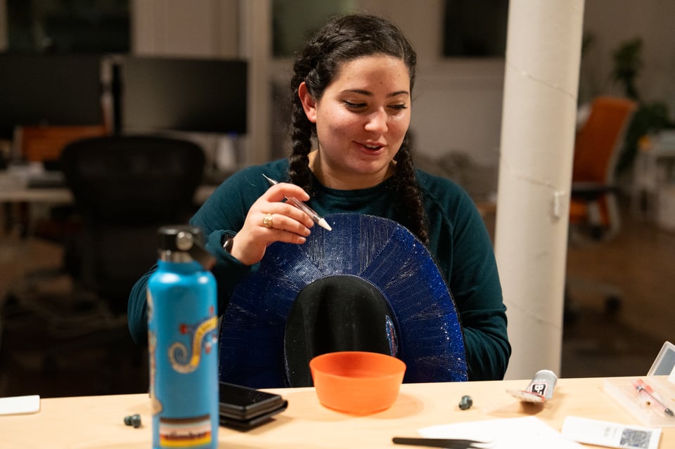 Sabrina bedazzling a hat.