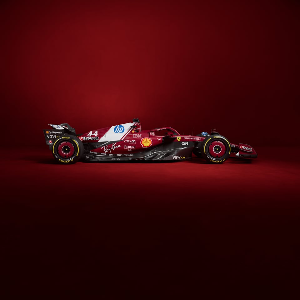 A very red Ferrari stylishly posed against a red background. A diagonal white stripe is featured on the engine cover and contains the HP logo.