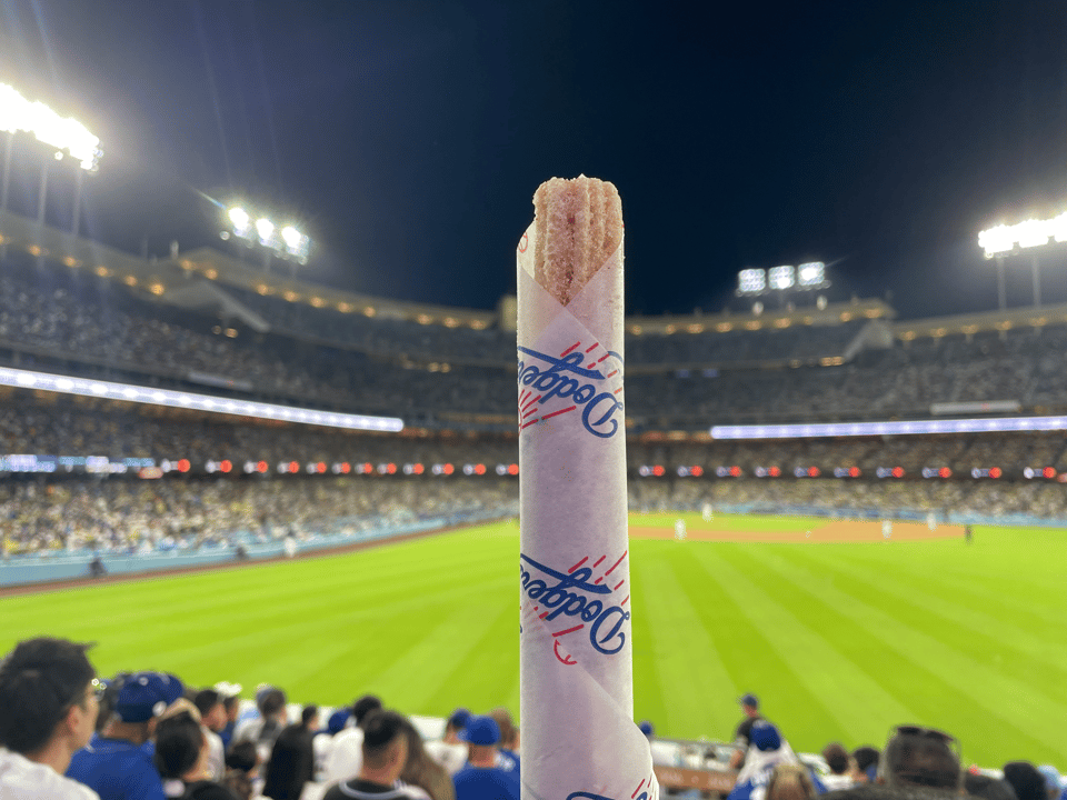 A wrapped churro in front of a baseball park at night