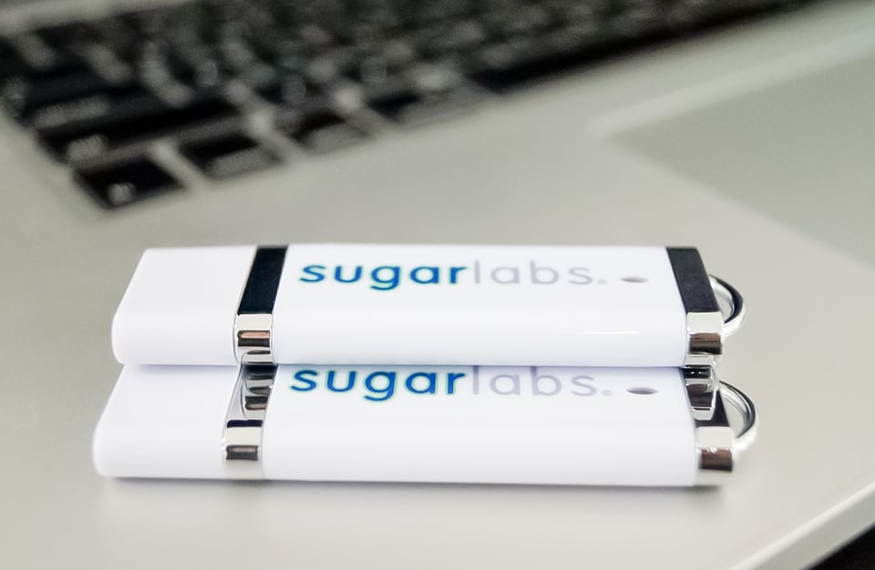 Two USB drives on a laptop. The Sugar Labs logo is prominent, and the drives are shiny.