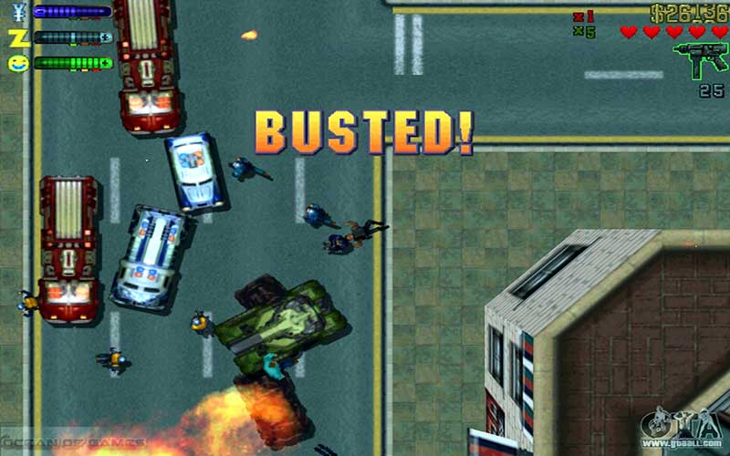 Screenshot of the original Grand Theft Auto video game, showing a view from above of a 2-D street scene in a city. There are two police cars and two red fire engines pulled to a stop in the middle of the street, at slight angles to another. Two police officers are out and pointing guns at a figure who is lying on the ground. There is a burning overturned car in the bottom of the screen. In large text in the center of the screen is the word "BUSTED!"