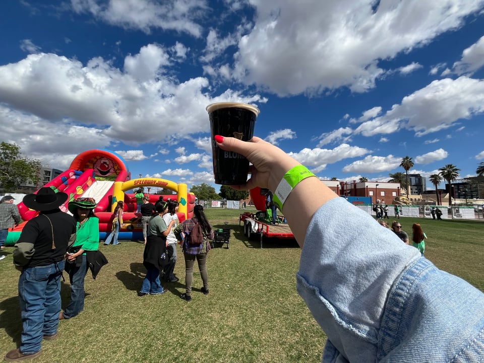 My red-manicured hand raising a glass of Guinness to the sky