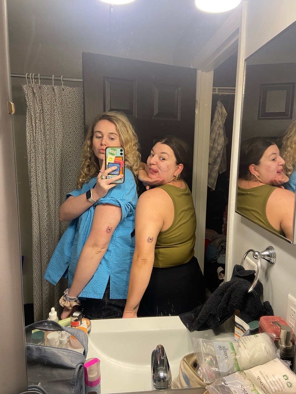 two women taking a selfie in a bathroom
