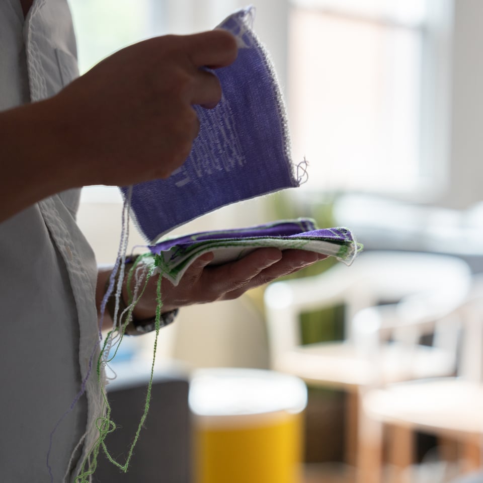 A man holding textile art.