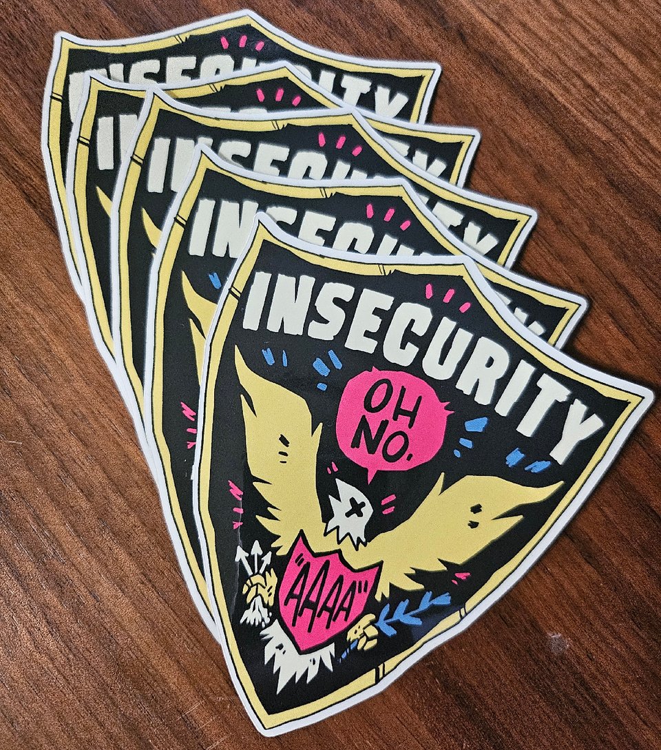 Five shield-shaped stickers on a wood surface. They resemble a Security badge, but instead say "Insecurity" and feature an eagle clutching a shield that says "aaaa" and saying "Oh no."