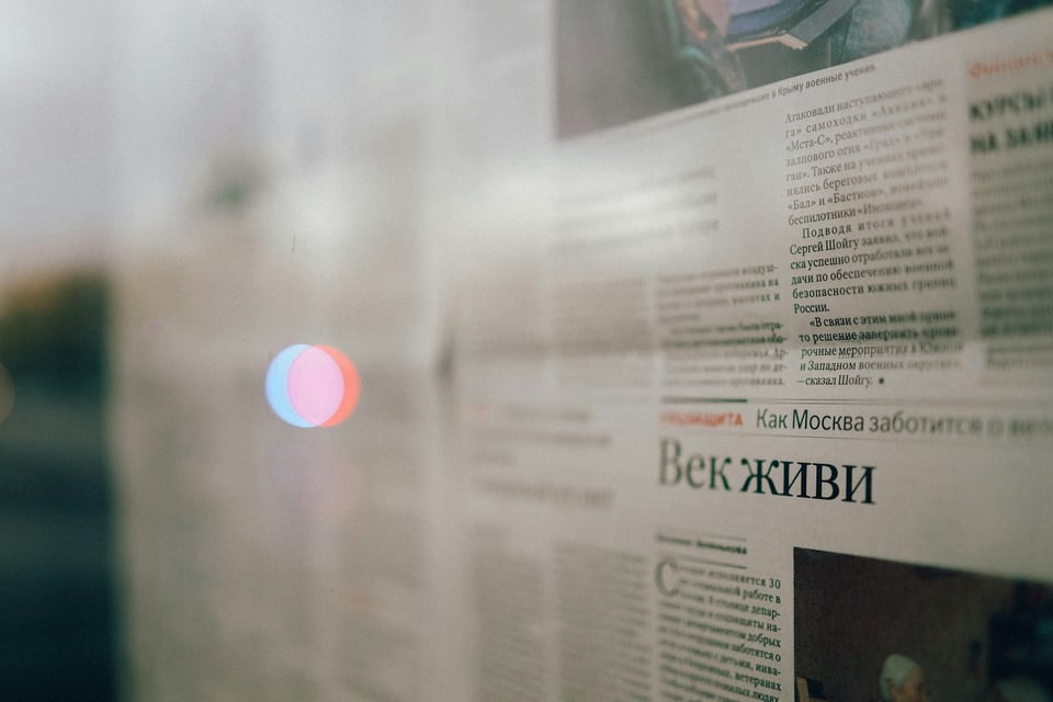 A close-up of a newspaper. Much of it is blurred but the clear portion is in Cyrilic letters. Photo by Artyom Korshunov on Unsplash.