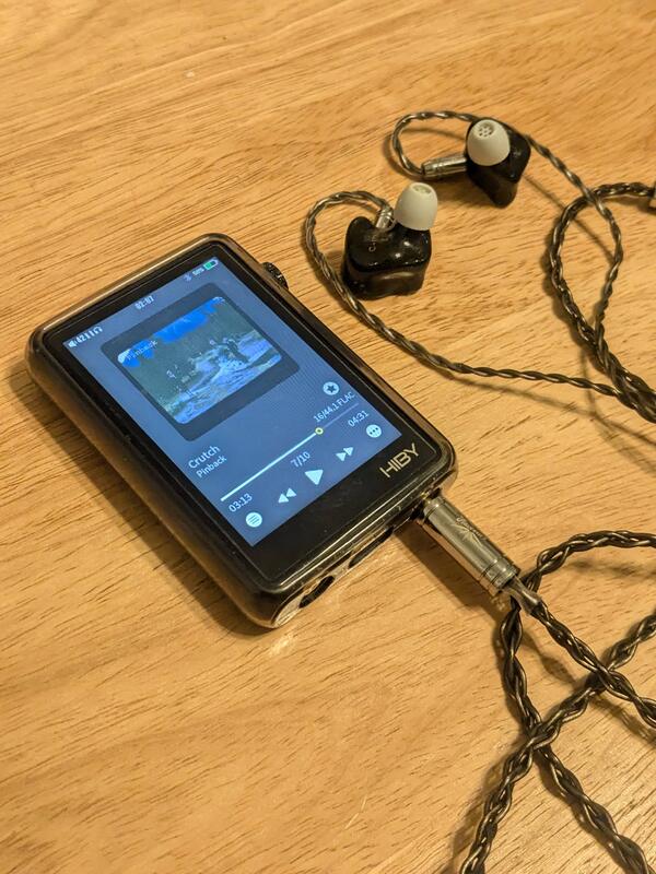 A pair of in-ear monitors plugged into a digital audio player.