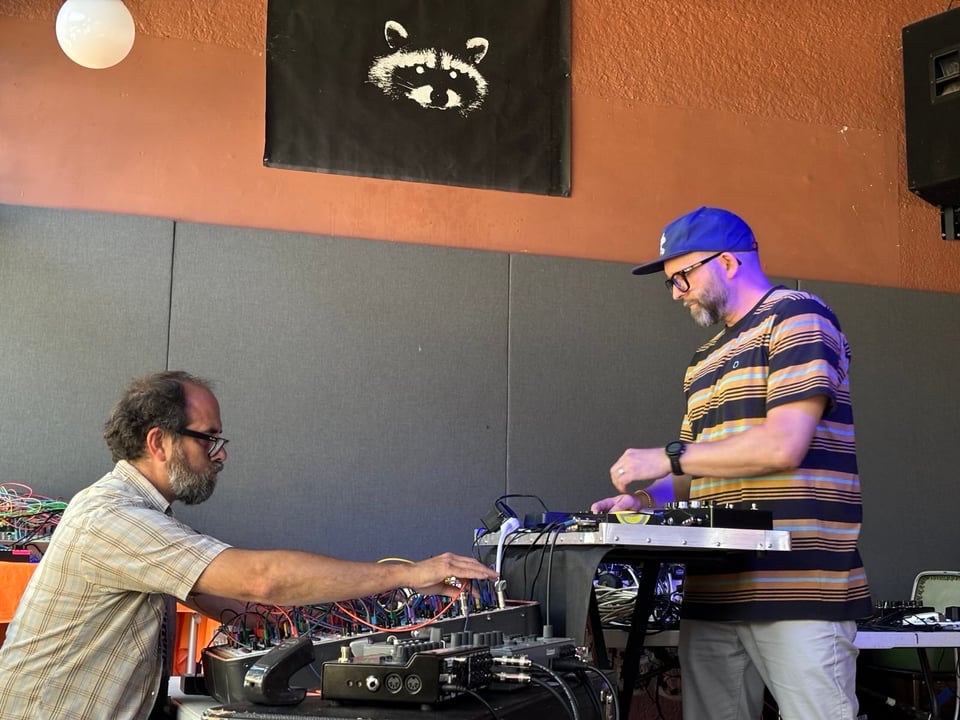 Free Static performing live standing over tables covered in electronic instruments