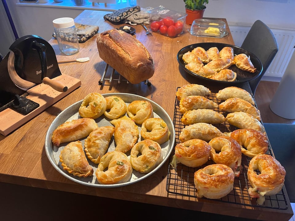 Kitchen island covered with empanadas cooling off.