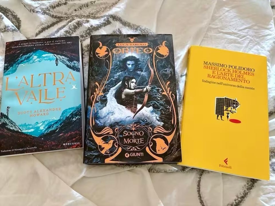 Three books on a bad. "L'Altra Valle", "Orfeto" and "Sherlock Holmes e l'Arte del Ragionamento"