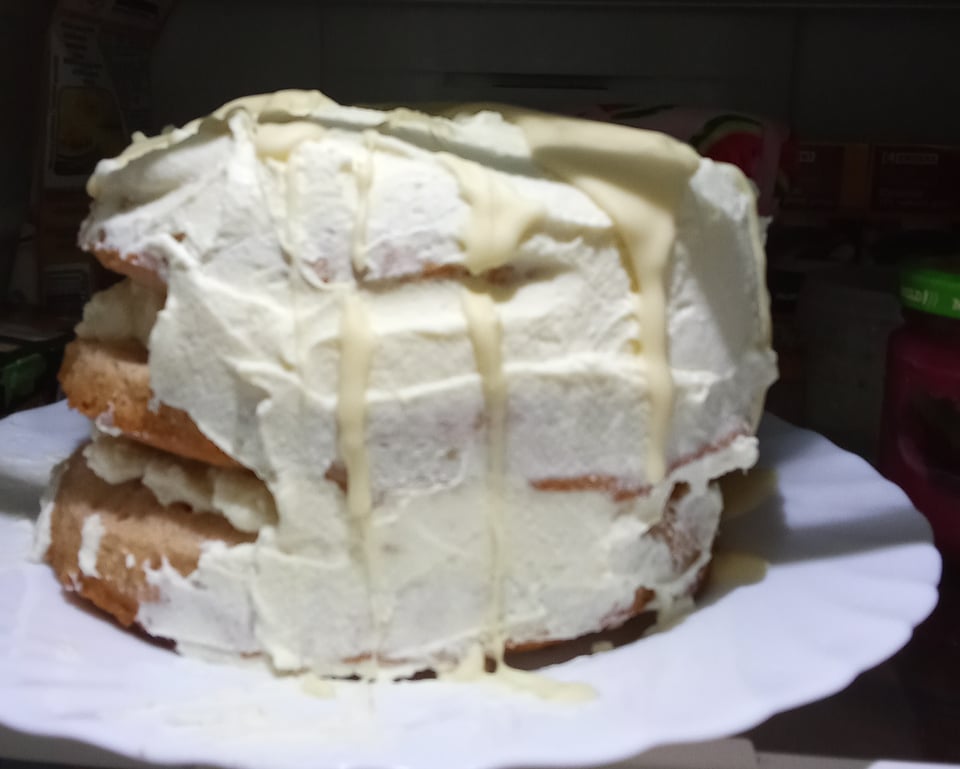A strawberry cake with white chocolate frosting that I worked really hard to make but looks like shit!
