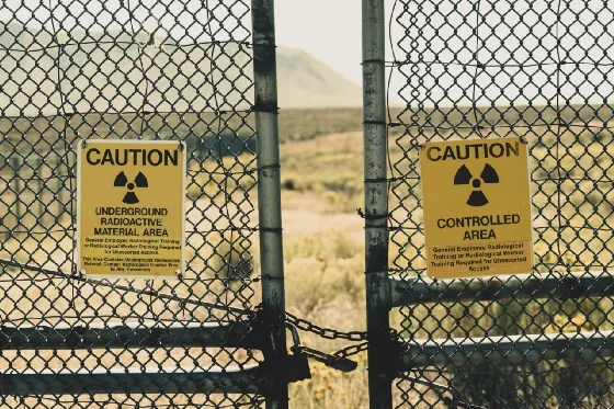 two caution signs on a chain link fence