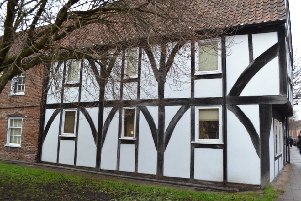 A black and white half timber house with a clay tile roof.