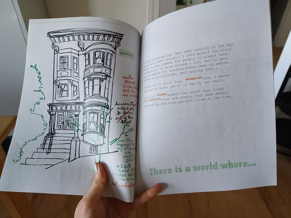 Hand holding a zine open to a spread which features an illustration of an SF Victorian on the left and copy on the right, with visible proofreading marks layered on top in red and green ink