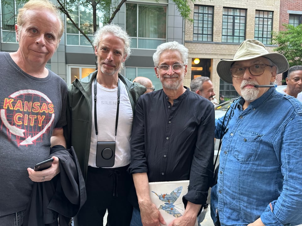 Photo of 4 white men on a sidewalk in New York City. From left to right: Tom Tomorrow, Gil Roth, Patrick McDonnell, and Art Spiegelman