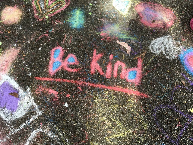chalk on a sidewalk that says "Be kind"