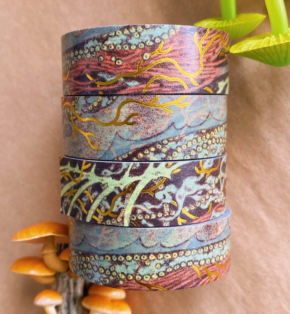 rolls of washi tape, with a stylized design of skin lifting away to reveal tissue, gold foil blood vessels, organs, and bones