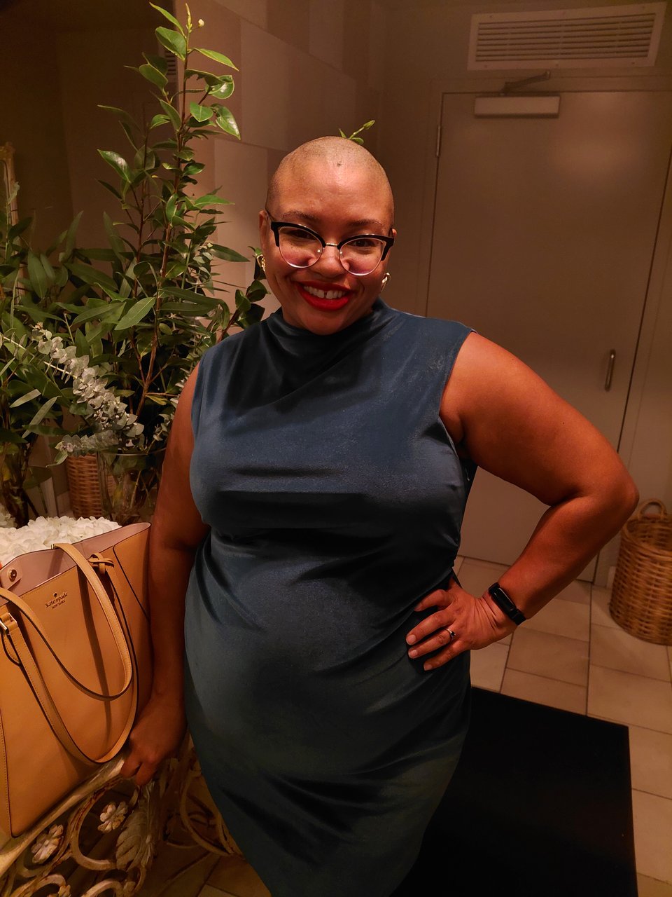 Bald Black woman in a green green dress posing