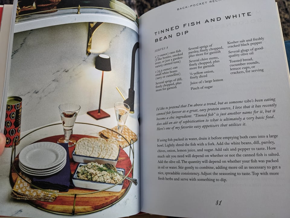 A page from Having People Over. The full color illustration is a tray of dip and crackers. The page opposite is a recipe for tinned fish and white bean dip.