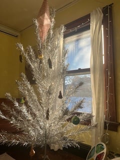 retro aluminum christmas tree lit up by the solstice morning sun through the window