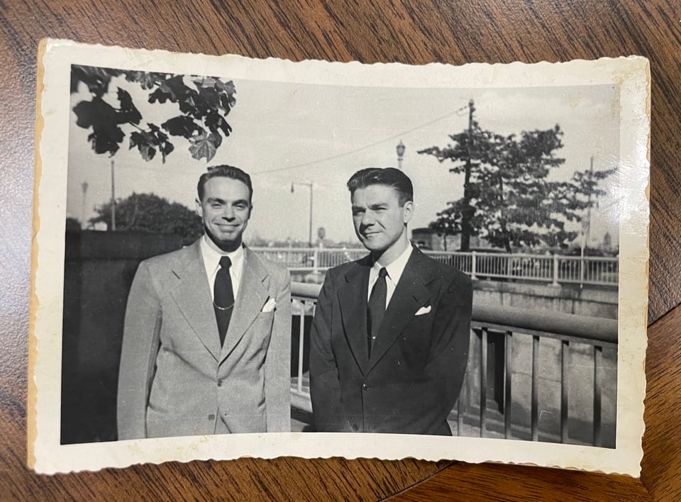 Two dapper looking fellows in a black and white photo from the 1950s or early 1960s, Donald stands on the left, Armand on the right