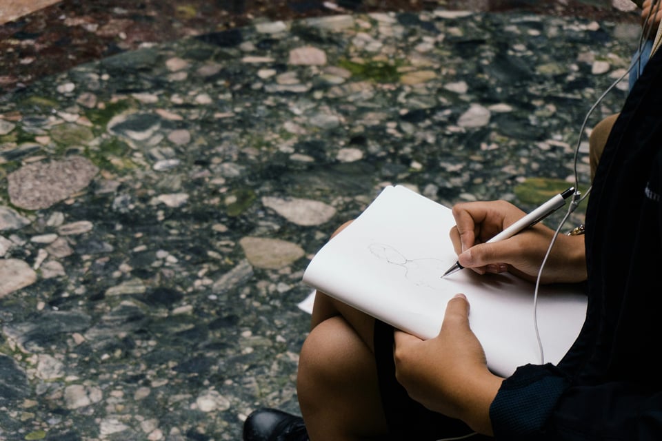 Stock image of a person writing in an open notebook.