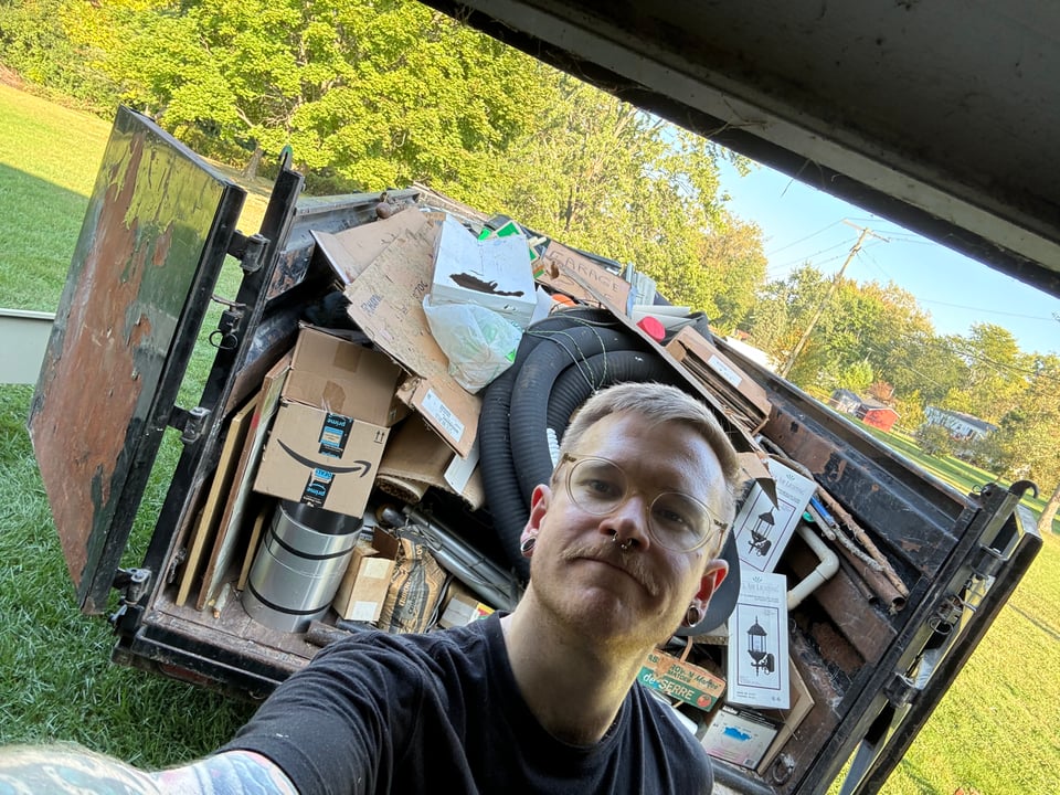 Me standing in front of a full dumpster of trash my parents should have thrown out years ago.