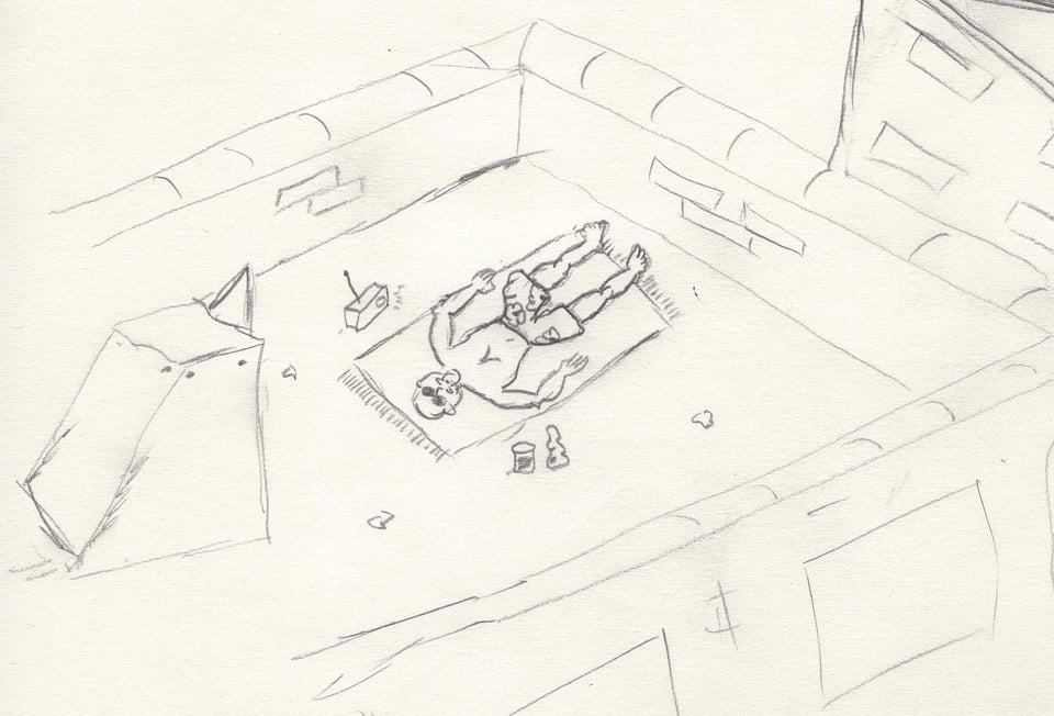 A man in bathjing suit lies on a blanket on an urban rooftop, listening to a radio