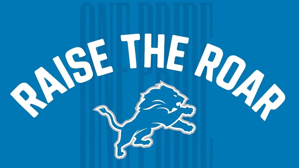 blue and white detroit lions flag featuring the lions logo and the words 'raise the roar' in an arc over head, with the words 'one pride' faded in the background