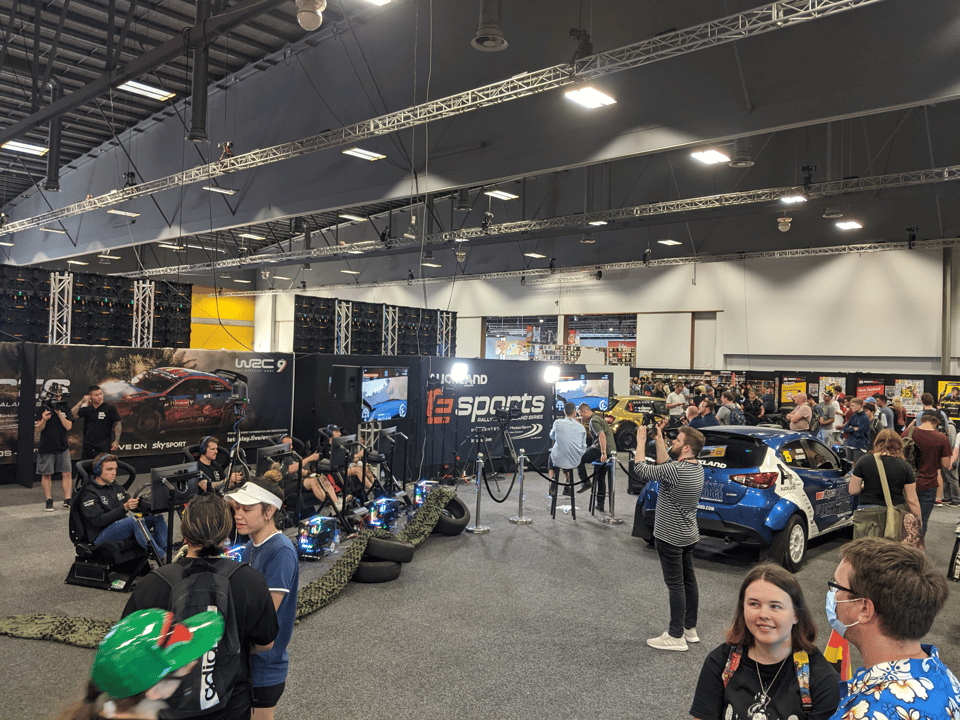 Rally NZ Esports setup at armaggedon with 8 sim rigs, tv production area, and an AP4 rally car