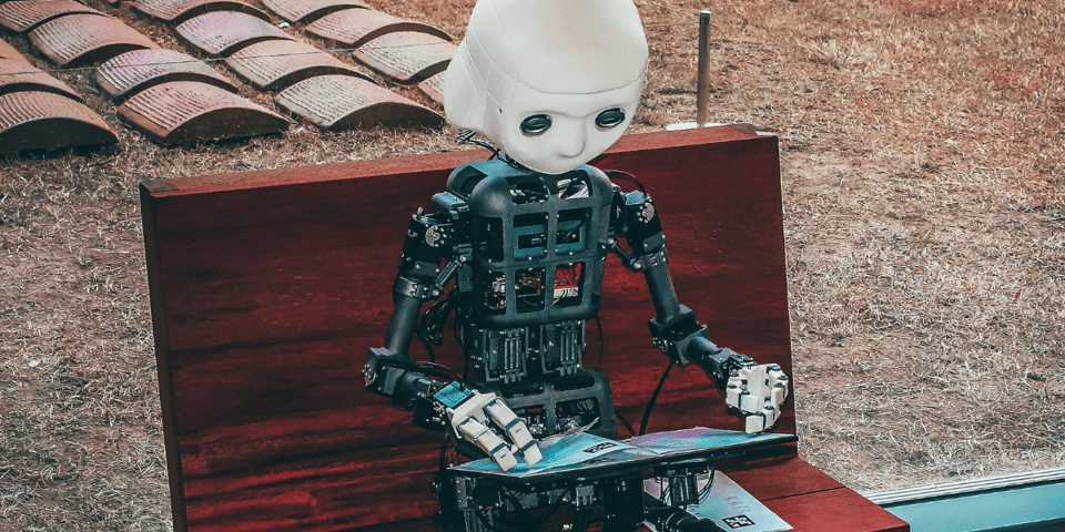 A little robot reads a book.