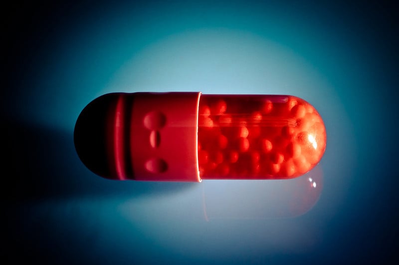 Image of a red pill on a blue background