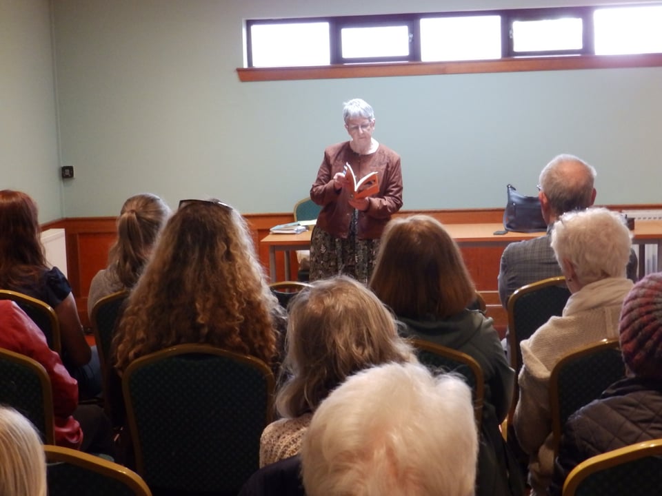 picture of the launch in Cambuslang, myself at the back in the centre, reading, in the foreground, my lovely friends who came to hear me.