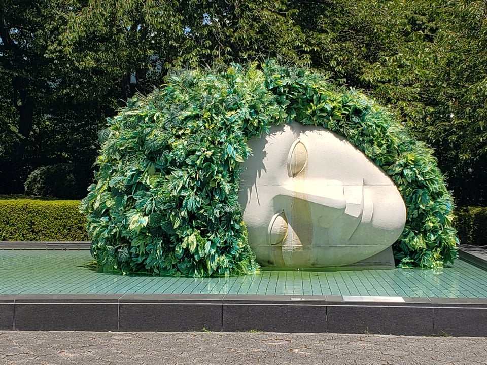 A statue of Gaia at the museum, wreathed in green leaves.