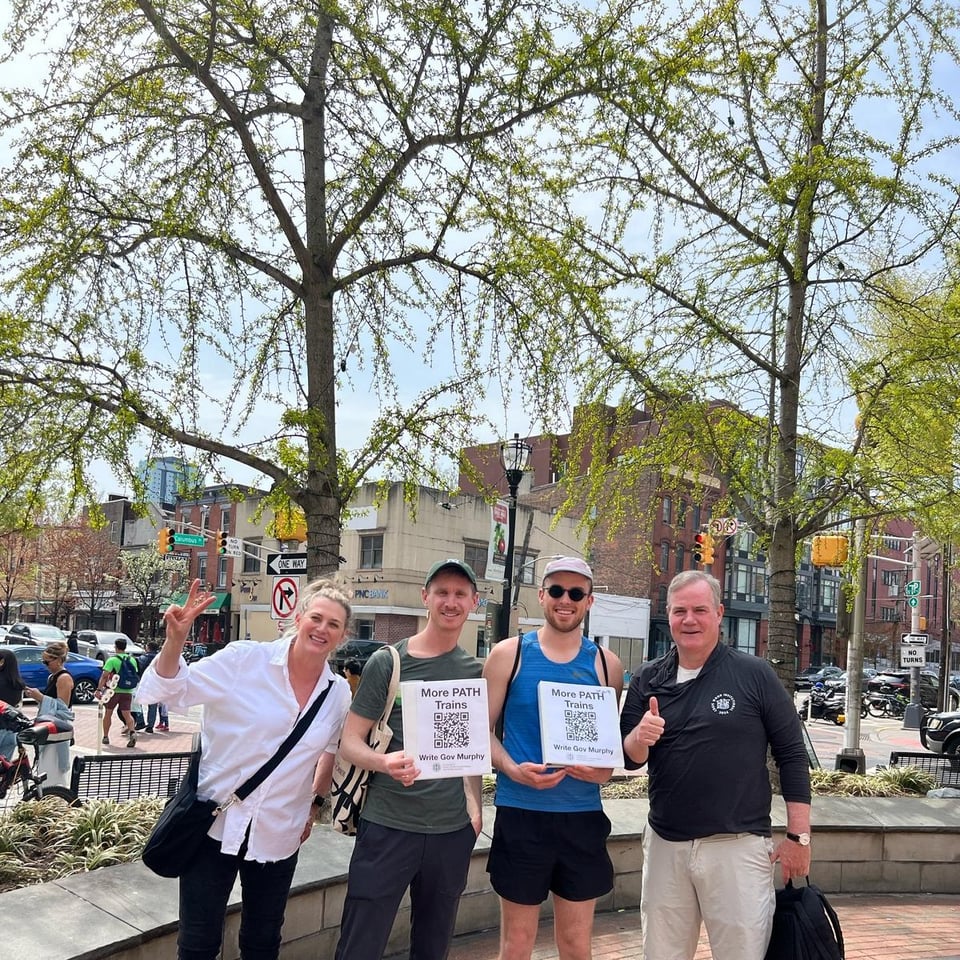 a group of people holding more path trains signs