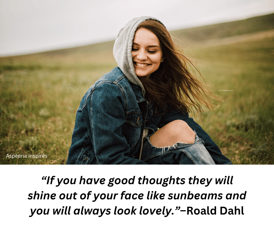 Lady wearing denims sitting on the grass smiling with a quote from Roald Dahl