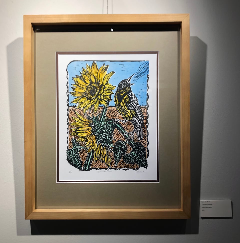 a linocut multicolor print of a bird on the stem of a sunflower