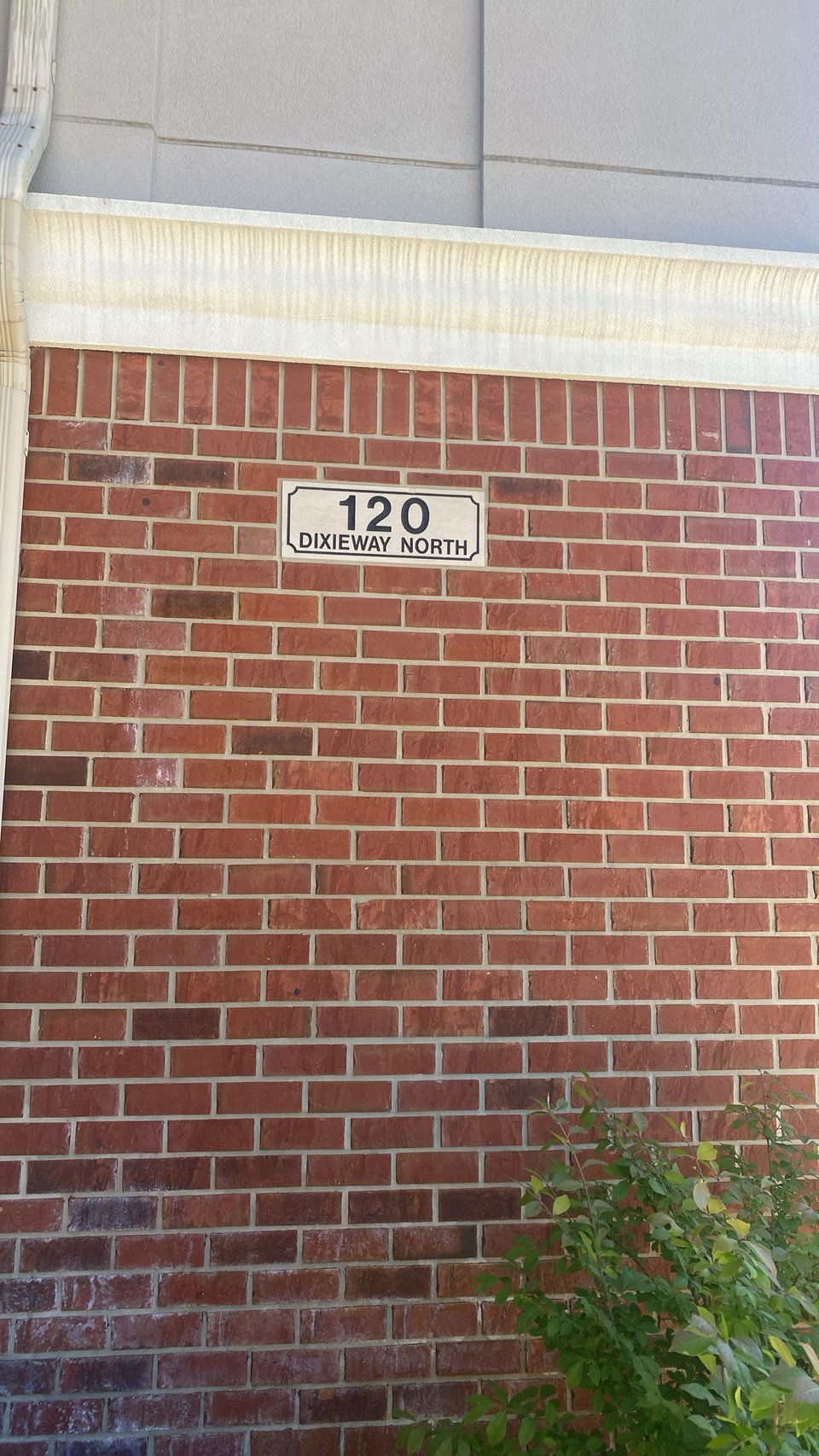 a brick wall exterior with a sign that reads 120 Dixieway North