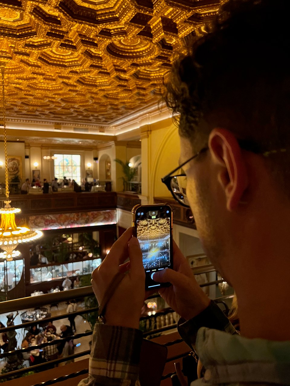 a man taking a picture of a ceiling in a restaurant