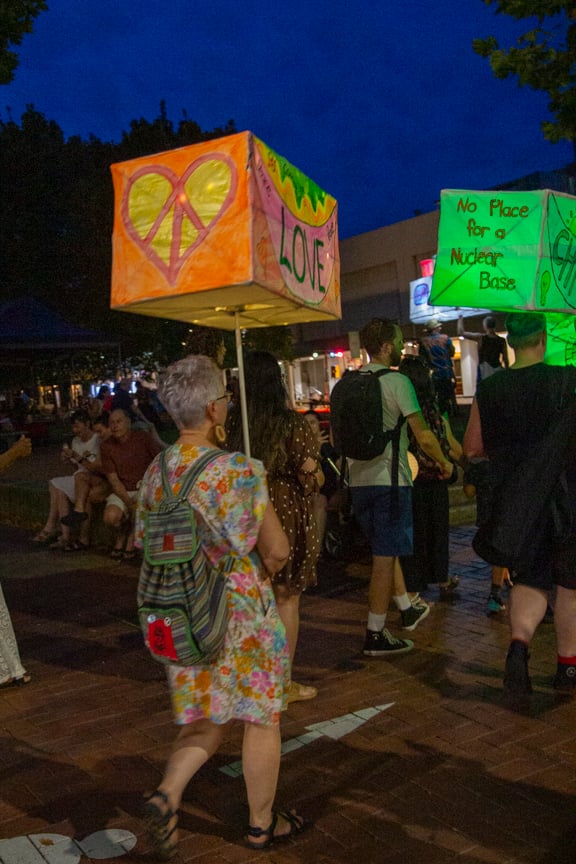 Lantern parade with lanterns marked with 'Love' and 'No Place for a Nuclear Base'