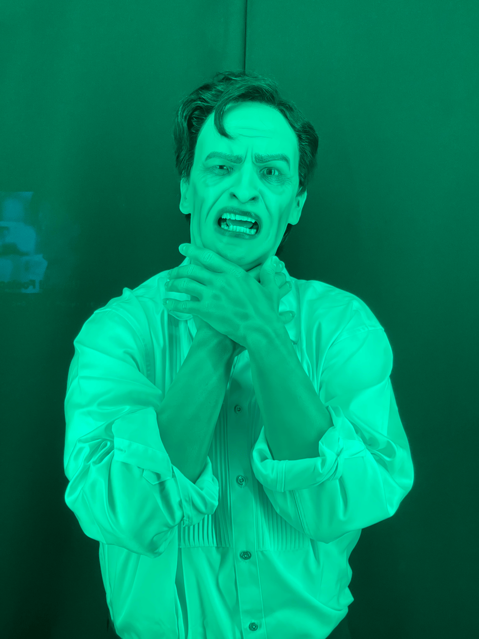 A model of actor Frederic March bathed in green light and grasping his throat
