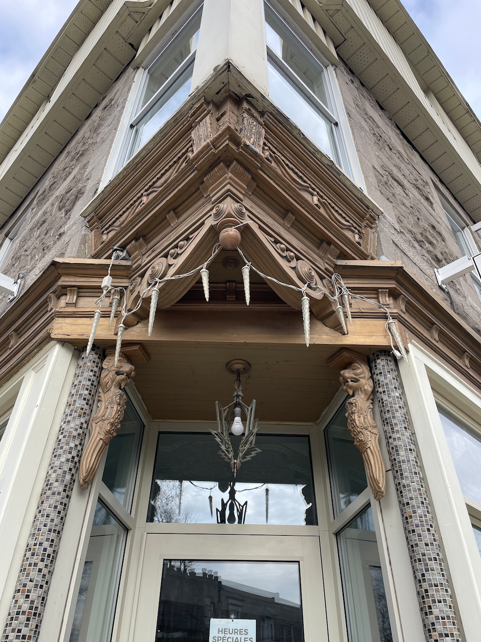 Image of a recessed door in the corenr of a building with ornate carvings above the opening.